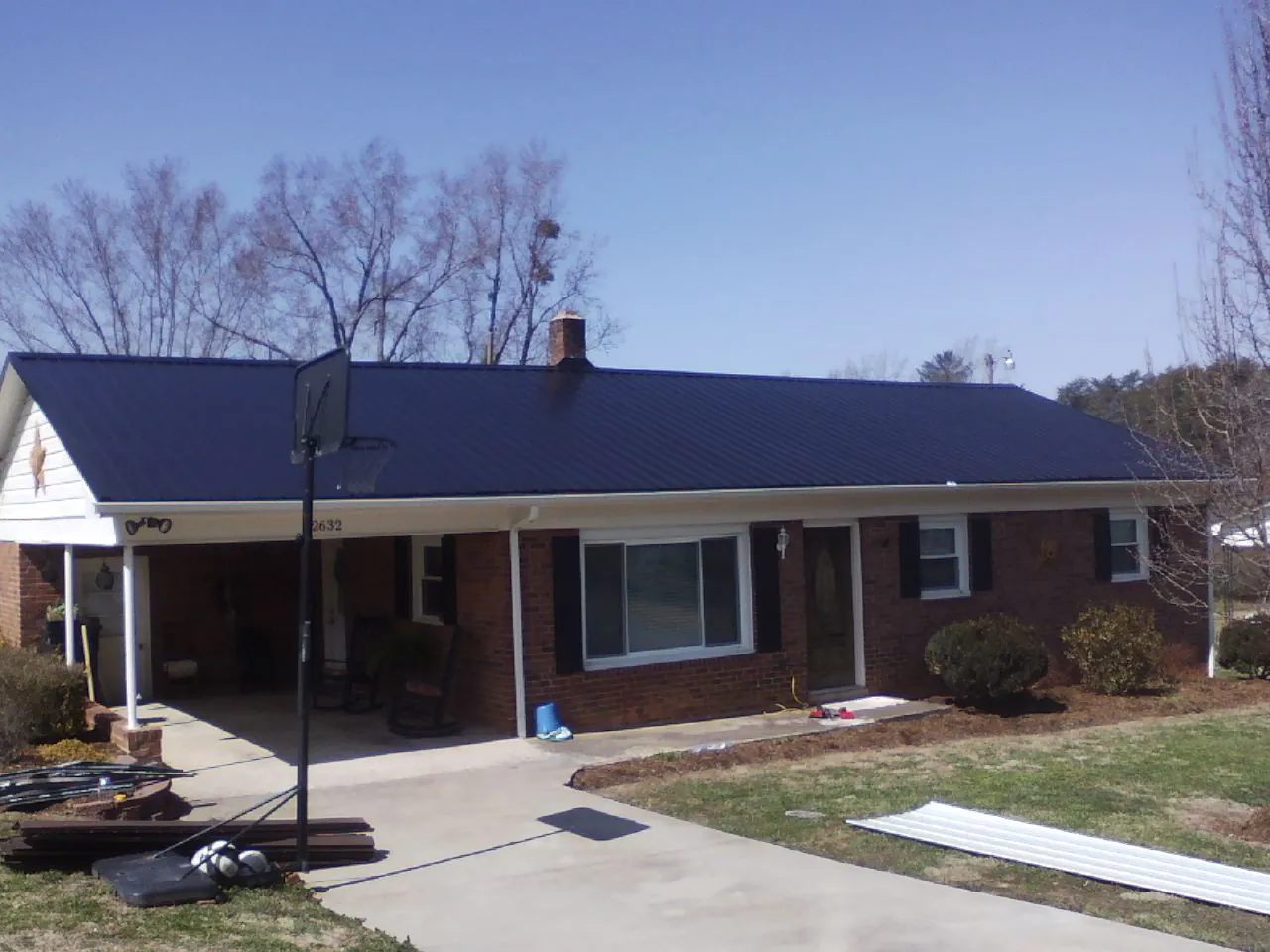 Finished dark blue metal roof on a brick ranch with a carport in West Columbia