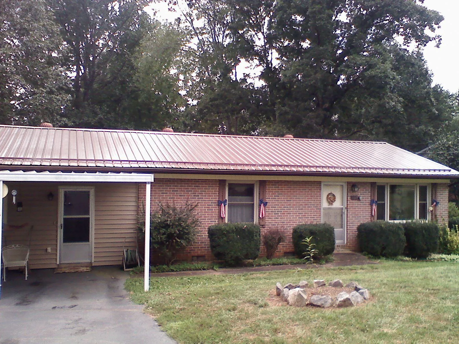 Bronze metal roof and carport on a brick ranch home — Roof Repair work by our crew in West Columbia